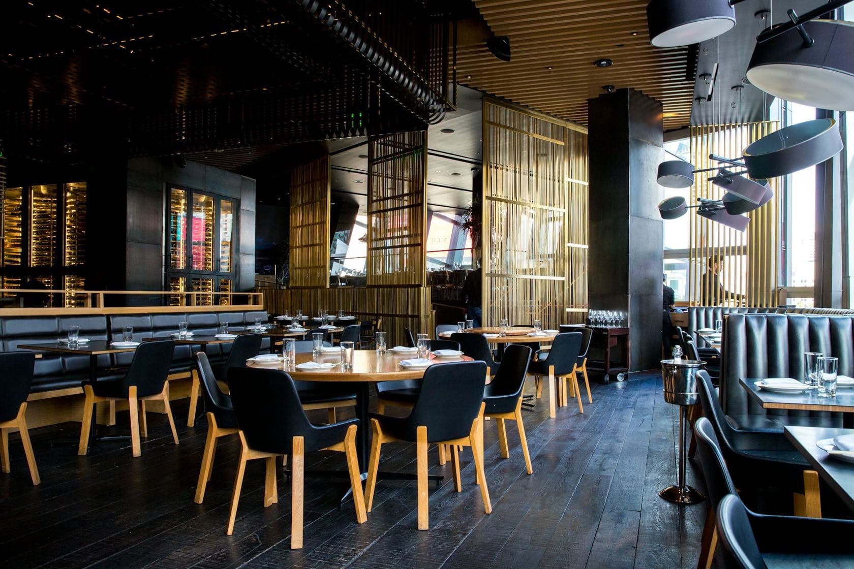 Salle de restaurant chaleureuse en soirée, tables dressées